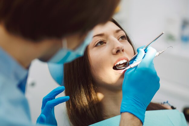 Inspección de los dientes de la mujer con la ayuda de un espejo.