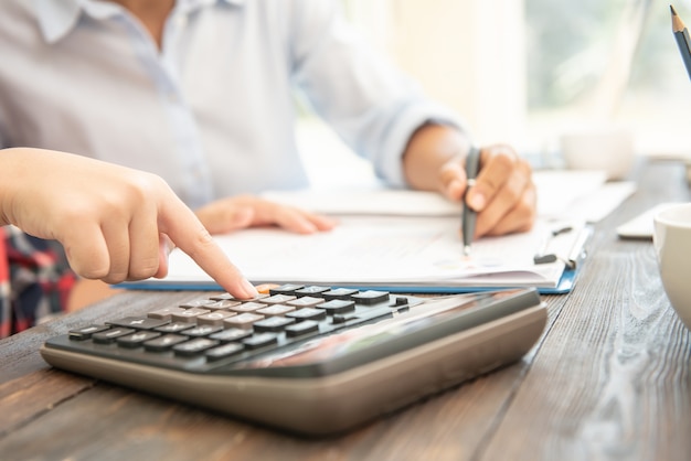 Inspector financiero de hombre de negocios administrador y secretaria haciendo informe, calculando el saldo.