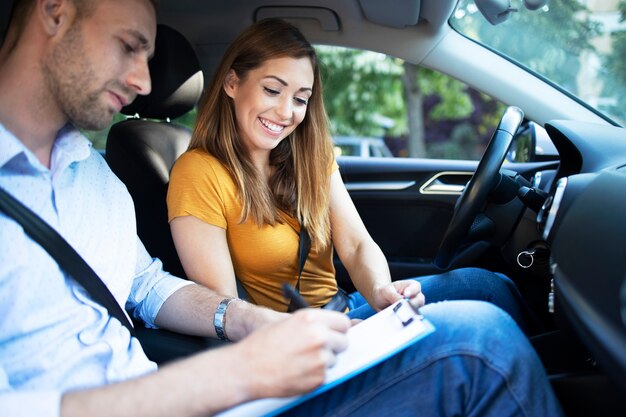 Instructor de automóvil explicando las reglas de tráfico de la ciudad antes de conducir un automóvil