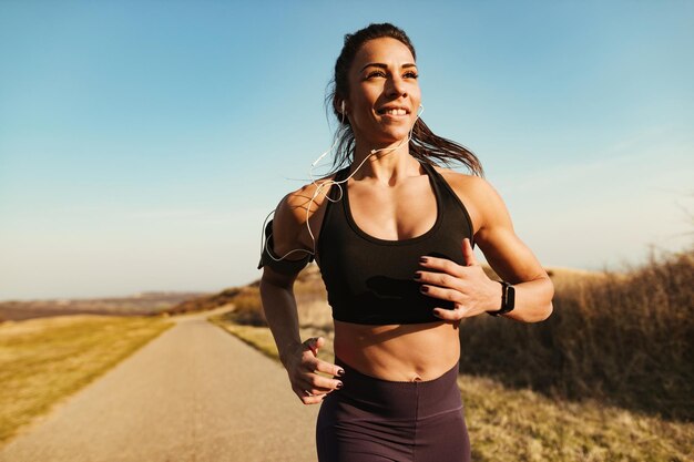 Instructor de fitness sonriente corriendo mientras hace ejercicio en la naturaleza Copiar espacio