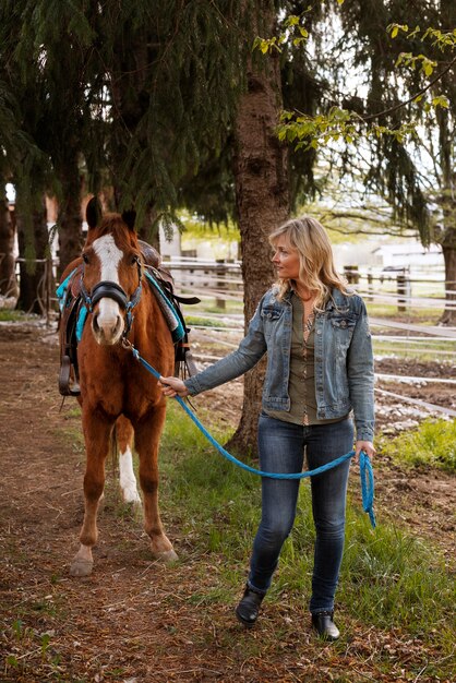 Instructora ecuestre femenina con caballo