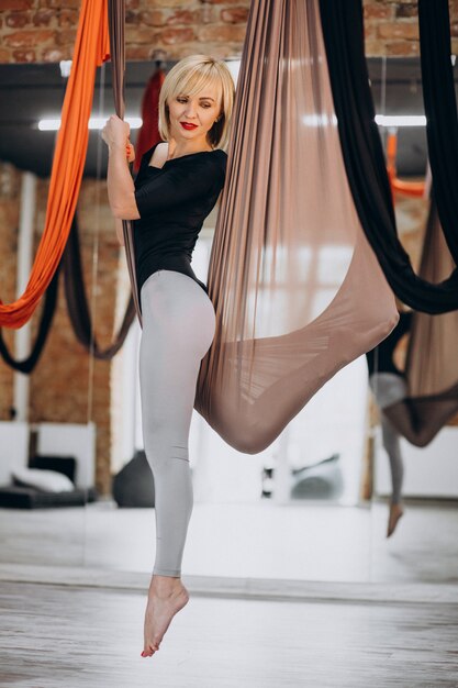 Instructora femenina de yoga con mosca en el gimnasio