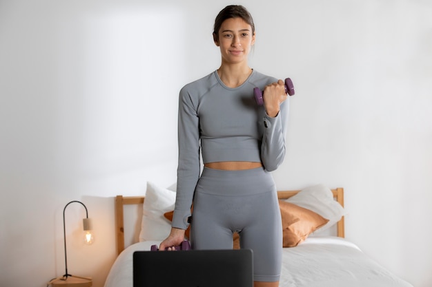 Foto gratuita instructora de fitness femenina haciendo ejercicio en casa