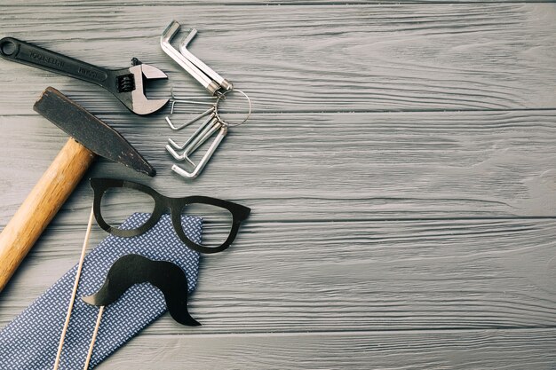 Instrumentos cerca de gafas decorativas y bigote con corbata.