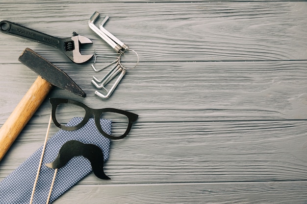 Instrumentos cerca de gafas decorativas y bigote con corbata.