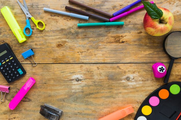 Instrumentos de escritura y manzana en círculo