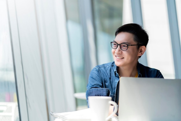 Inteligente, atractivo, positivo, hombre de negocios asiático, con gafas, trabajo remoto, nuevo estilo de vida normal, uso manual, portátil, teleconferencia, videollamada en vivo, reunión, concepto de ideas de negocios remotos.