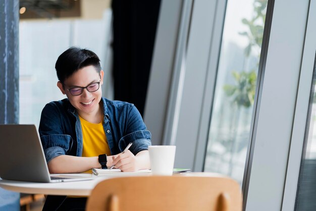 Inteligente, atractivo, positivo, hombre de negocios asiático, con gafas, trabajo remoto, nuevo estilo de vida normal, uso manual, portátil, teleconferencia, videollamada en vivo, reunión, concepto de ideas de negocios remotos.