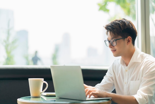 Inteligente, atractivo, positivo, hombre de negocios asiático, con gafas, trabajo remoto, nuevo estilo de vida normal, uso manual, portátil, teleconferencia, videollamada en vivo, reunión, concepto de ideas de negocios remotos.