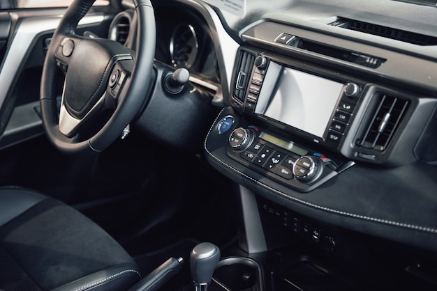 Interior del automóvil de lujo: volante, palanca de cambios, tablero y computadora