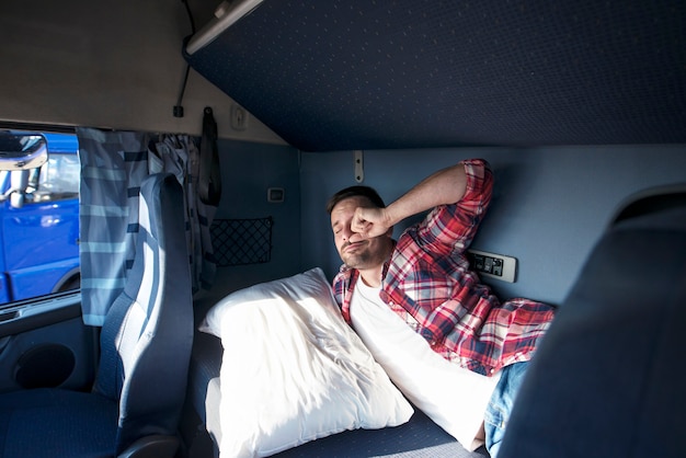 Interior de la cabina del camión con conductor durmiendo en la cama