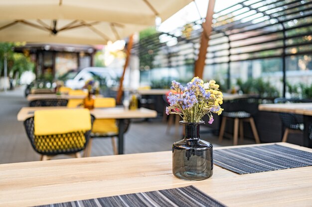 Interior del café de la calle de verano en la calle, adornado con árboles decorativos y sombrillas