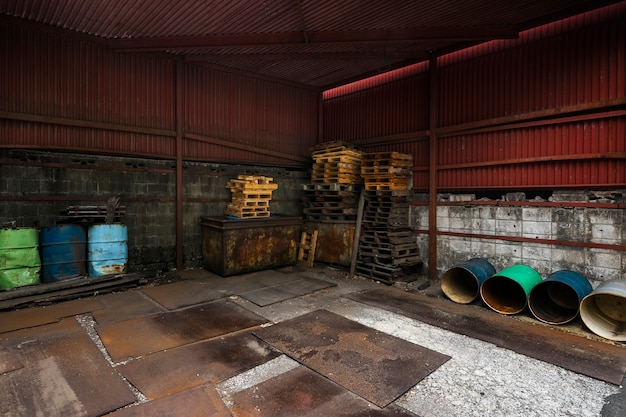 Interior de casa abandonada con barriles