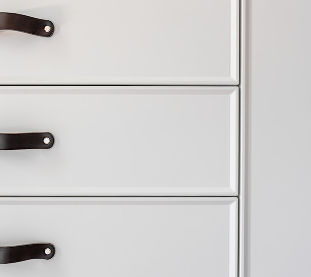 Foto gratuita interior de una casa residencial moderna: detalle de las manijas de las puertas del cajón de cocina negro.