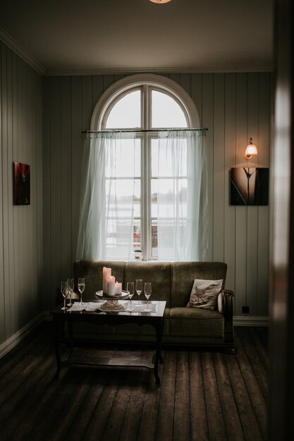 Interior de una casa con un sofá y copas de champán sobre la mesa