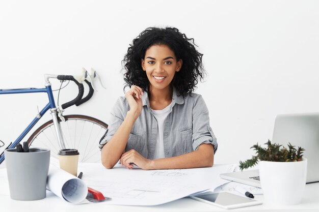 Interior cintura para arriba retrato de alegre joven ingeniero autodeterminado sentirse feliz