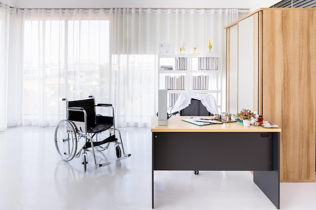 Interior de consultorio médico vacío en hospital clínico con silla de ruedas