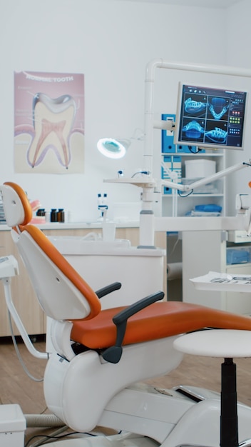 Foto gratuita interior del consultorio de ortodoncia de estomatología dentista con radiografía de dientes en el monitor