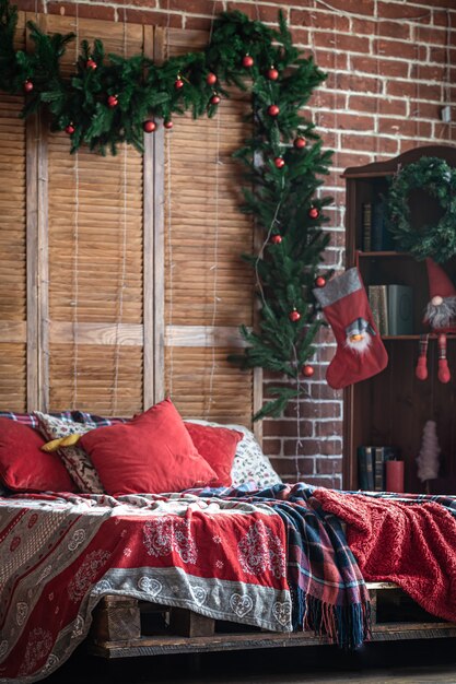 Interior de dormitorio de Navidad con colores rojo-verde con un árbol de Navidad