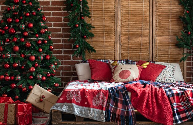 Interior de dormitorio de Navidad con colores rojo-verde con un árbol de Navidad