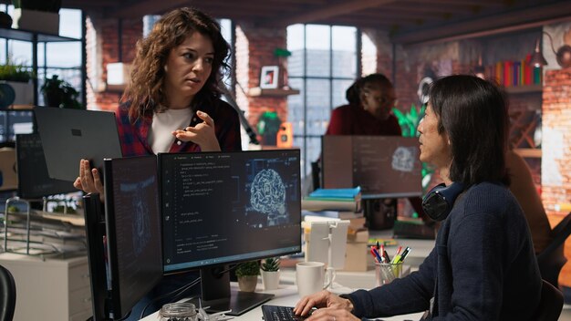 Un interno de una startup de IA con una computadora portátil le hace preguntas a un técnico senior