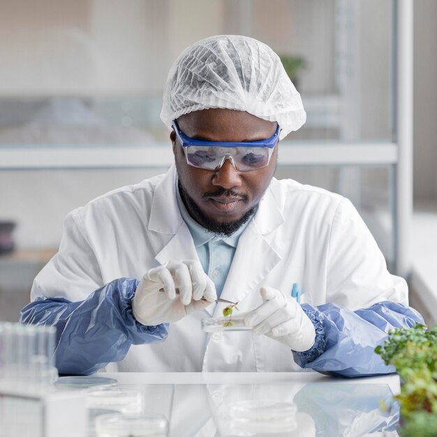 Investigador masculino en el laboratorio de biotecnología con placa de Petri