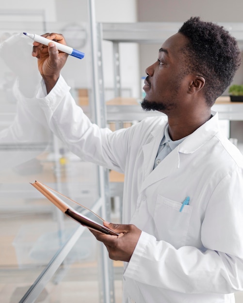 Foto gratuita investigador masculino con tableta en el laboratorio de biotecnología