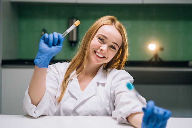 Investigador médico o científico femenino tiene en las manos un tubo de ensayo.