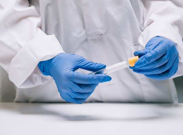 Investigador médico o científico femenino tiene en las manos un tubo de ensayo