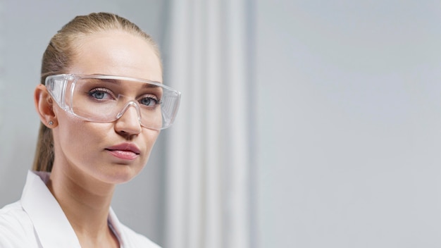 Investigadora en el laboratorio con gafas de seguridad y espacio de copia