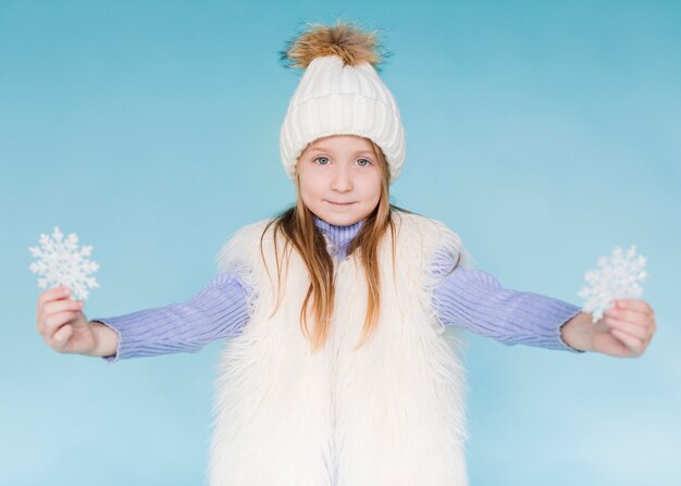 Invierno vestido niña sosteniendo copos de nieve