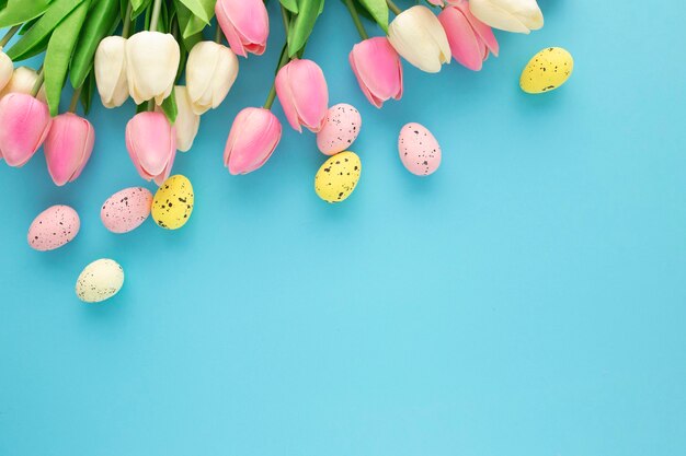 Invitación de Pascua con tulipanes sobre un fondo azul con espacio de copia