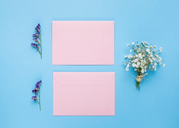 Invitaciones de boda planas junto a flores.