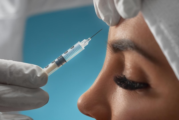 Inyección de botox cosmético en la frente femenina