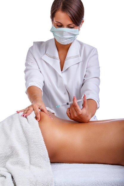 Inyección de jeringa en la espalda de la mujer. Mujer disfrutando de un relajante masaje de espalda en el centro de spa de cosmetología.