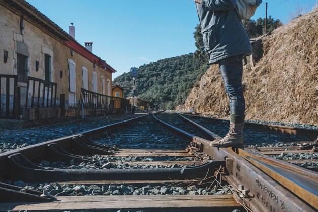 Irreconocible turista de pie en el ferrocarril