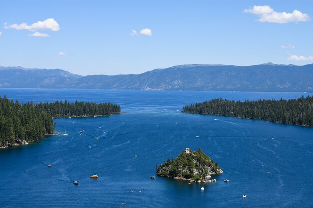 Una isla aislada en el océano rodeada de islas de abetos y altas montañas rocosas.