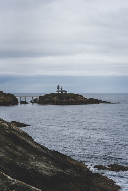 Isla rocosa rodeada por el mar bajo un cielo nublado