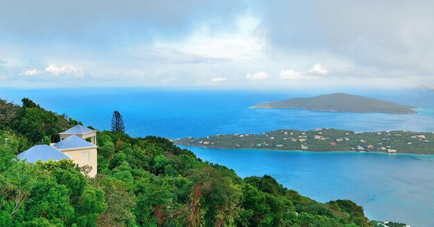 Islas Vírgenes Santo Tomás panorama vista a la montaña con nubes, edificios y costa de playa.