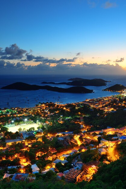 Islas Vírgenes Santo Tomás puesta de sol vista a la montaña con nubes coloridas, edificios y costa de playa.