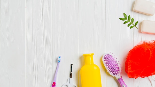 Jabón; cepillo de dientes; cortar con tijeras; Cepillo y esponja sobre fondo de madera