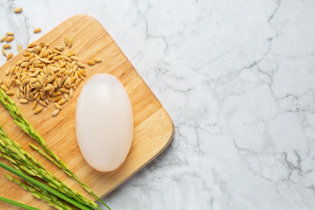 Jabón de leche de arroz puesto en prueba de madera con plantas de arroz y semillas de arroz