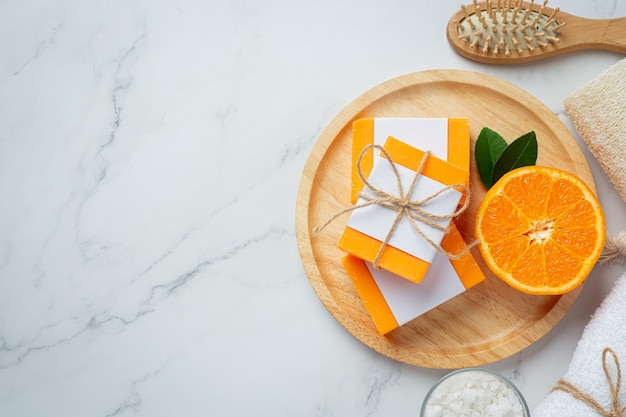 Jabón de naranja con naranja fresca sobre fondo de mármol