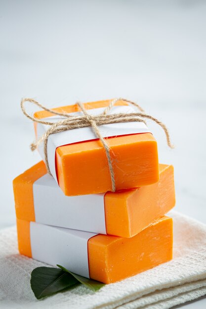Jabón de naranja con naranja fresca sobre fondo de mármol