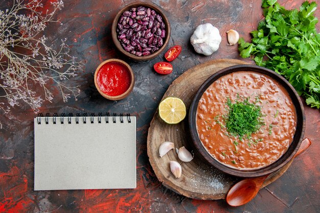 Jabón de tomate clásico frijoles cuchara de ajo botella de aceite ketchup de limón y cuaderno en la mesa de colores mezclados