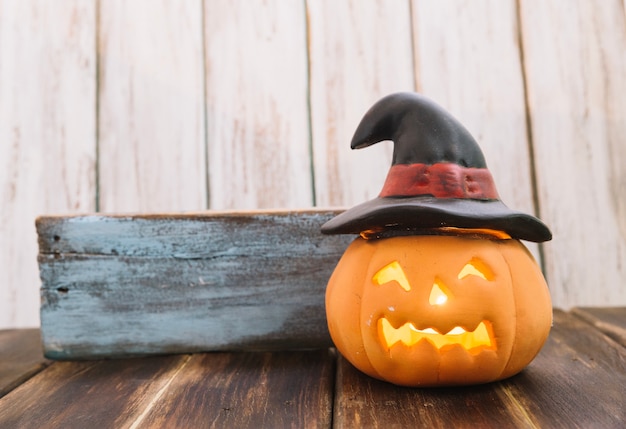 Foto gratuita jack-o-linterna en el sombrero de bruja y la madera