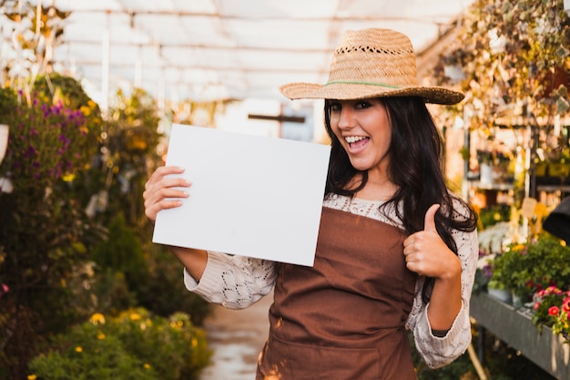 Foto gratuita jardinero con hoja de papel gesticular pulgar arriba