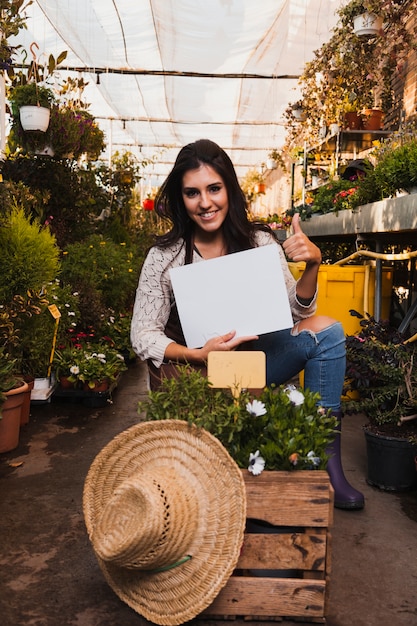 Foto gratuita jardinero con hojas de papel que aprueban las plantas