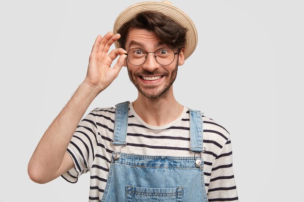 Jardinero macho joven encantado con sonrisa positiva