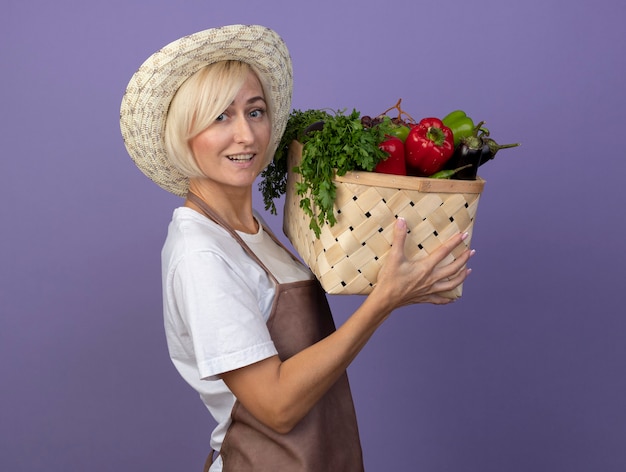 Jardinero rubio de mediana edad alegre mujer en uniforme con sombrero